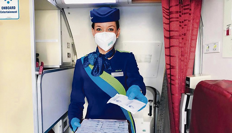 Eine Flugbegleiterin von Binter bietet antiseptische Feuchttücher an. Foto: Binter