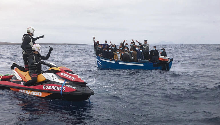 Großes Glück hatten die Insassen dieser Patera, die am 13. August den Norden von Lanzarote erreichte. Beamte signalisieren den Migranten aus dem Maghreb, zu warten, bis das Schiff der Seenotrettung eintrifft, um sie aufzunehmen. Foto: EFE/Consorcio de Emergencias de Lanzarote