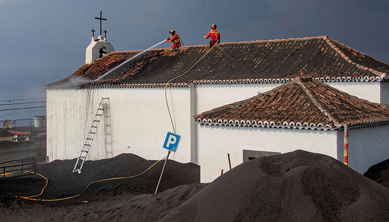 Der Vulkan hat La Palma weiter fest im Griff: Die Einwohner der betroffenen Orte auf La Palma sind seit Wochen damit beschäftigt, Asche von allen Oberflächen zu entfernen. Feuerwehrkräfte und Soldaten der Katastrophenschutz-Spezialeinheit UME sind im Dauereinsatz, um Dächer freizuräumen. Fotos: EFE