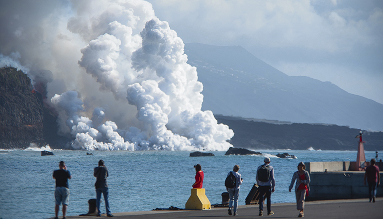Spannend und gefährlich: Einige Menschen beobachteten vom Hafen von Tazacorte aus, wie sich nach dem Eintritt der Lava ins Meer eine riesige Dampfwolke bildete. Foto: EFE