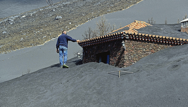 Julio Rodríguez begutachtet den Fortschritt bei der Freilegung seines Hauses, ganz in der Nähe des Vulkans. Foto: Elvira Urquijo/EFE